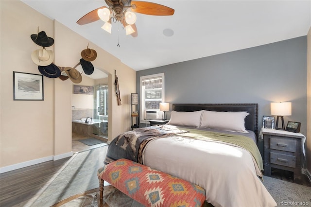 bedroom with vaulted ceiling, ceiling fan, cooling unit, hardwood / wood-style floors, and connected bathroom