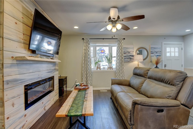 living area with a healthy amount of sunlight, recessed lighting, dark wood-style flooring, and a glass covered fireplace