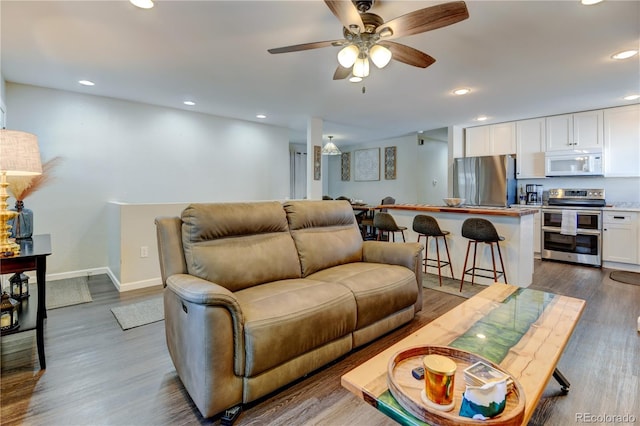 living room with dark wood-style floors, ceiling fan, baseboards, and recessed lighting