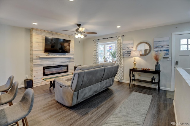 living room featuring a fireplace, wood finished floors, a wealth of natural light, and baseboards