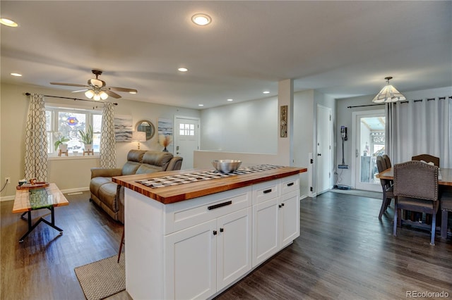 kitchen with dark wood-style floors, butcher block countertops, white cabinets, and open floor plan