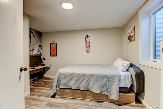 bedroom featuring baseboards and wood finished floors