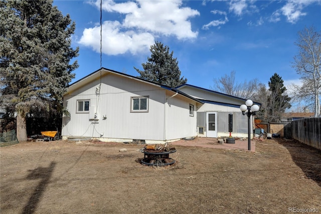 back of house with crawl space, an outdoor fire pit, and fence