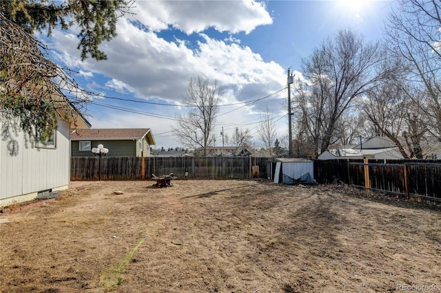 view of yard featuring a fenced backyard, an outdoor structure, and a shed