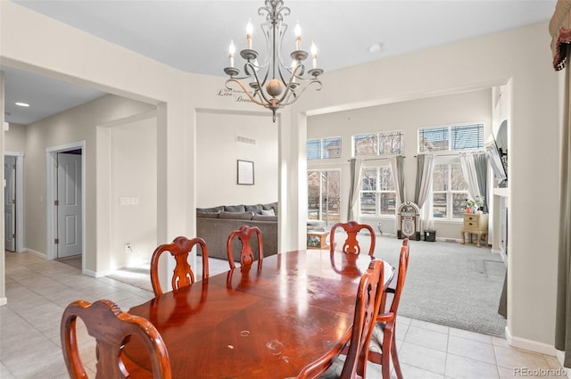 dining room featuring light tile patterned floors, baseboards, an inviting chandelier, and light colored carpet