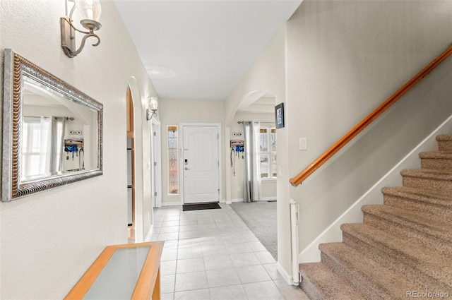 foyer entrance featuring light carpet and a wealth of natural light