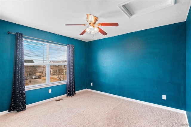 unfurnished room with attic access, carpet, visible vents, and baseboards