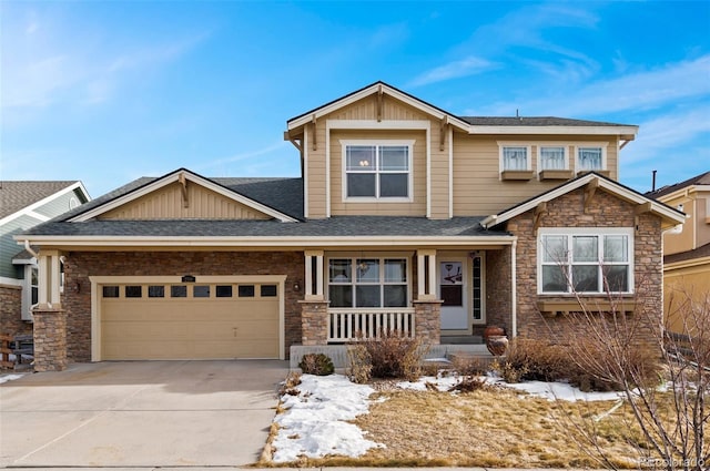 craftsman house featuring driveway, a shingled roof, stone siding, an attached garage, and covered porch