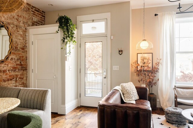 sitting room featuring light wood-type flooring and brick wall