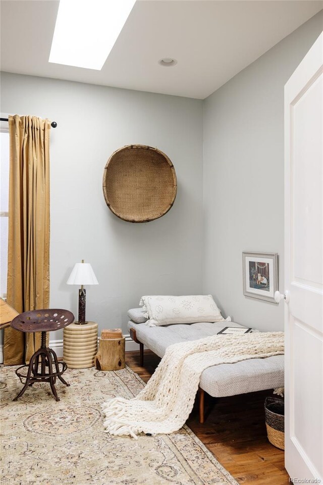 bedroom with a skylight and hardwood / wood-style flooring