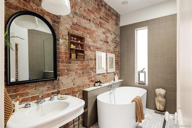 bathroom featuring a tub, sink, and tile patterned flooring