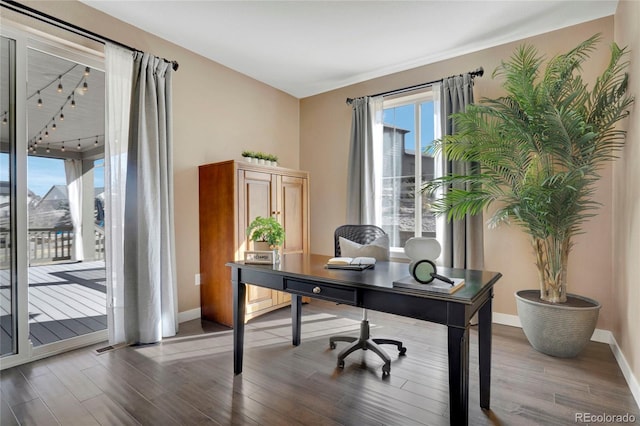 home office with baseboards, wood finished floors, and rail lighting