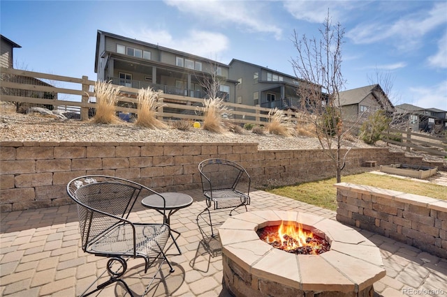 view of patio featuring a residential view, a fire pit, and fence