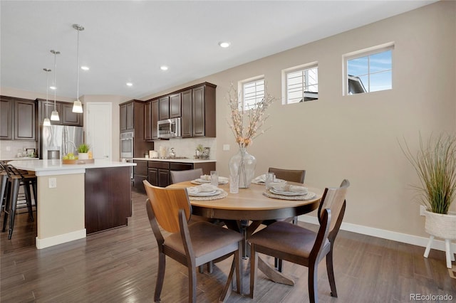 dining space with baseboards, dark wood finished floors, and recessed lighting