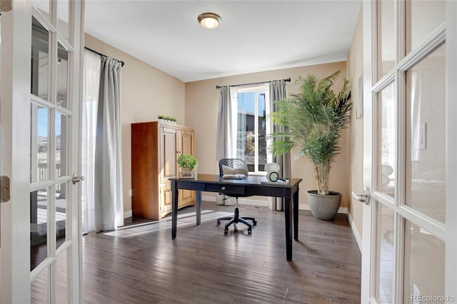 home office with dark wood-type flooring, french doors, and baseboards