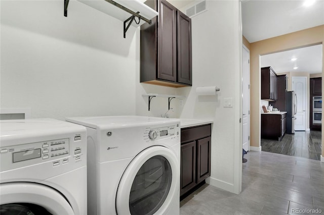 clothes washing area featuring a sink, cabinet space, visible vents, washer and dryer, and baseboards