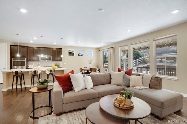 living area featuring light wood-style floors, recessed lighting, and baseboards