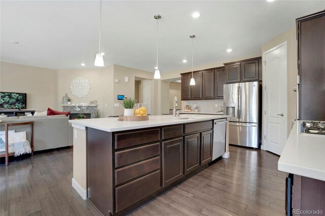 9772 Taylor River Cir, Littleton, CO 80125 - kitchen with dark brown cabinets, a sink, dark wood-type flooring, light countertops, and appliances with stainless steel finishes