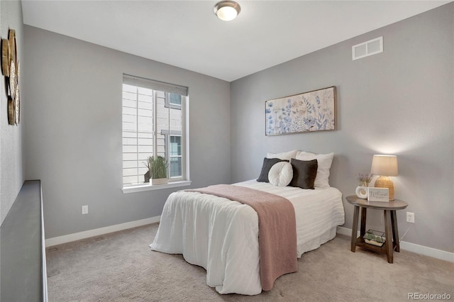 bedroom featuring visible vents, baseboards, and light carpet