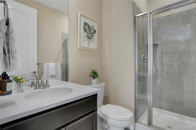 bathroom featuring a stall shower, toilet, and vanity