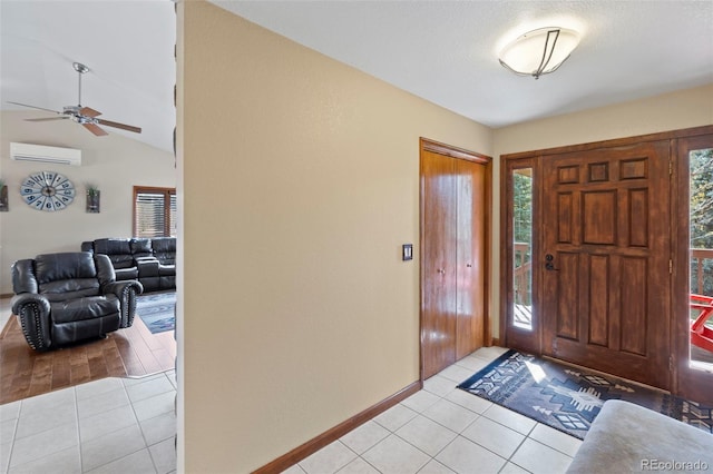 tiled foyer with ceiling fan, vaulted ceiling, and a wall mounted AC