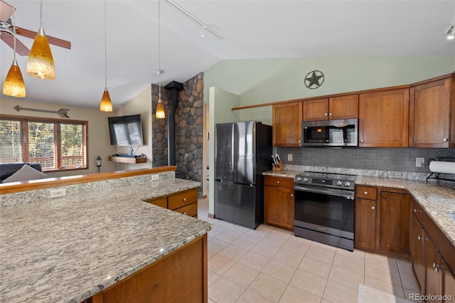 kitchen with decorative light fixtures, a wood stove, stainless steel appliances, backsplash, and lofted ceiling