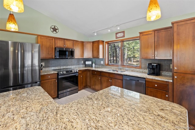 kitchen featuring stainless steel appliances, sink, vaulted ceiling, decorative light fixtures, and backsplash