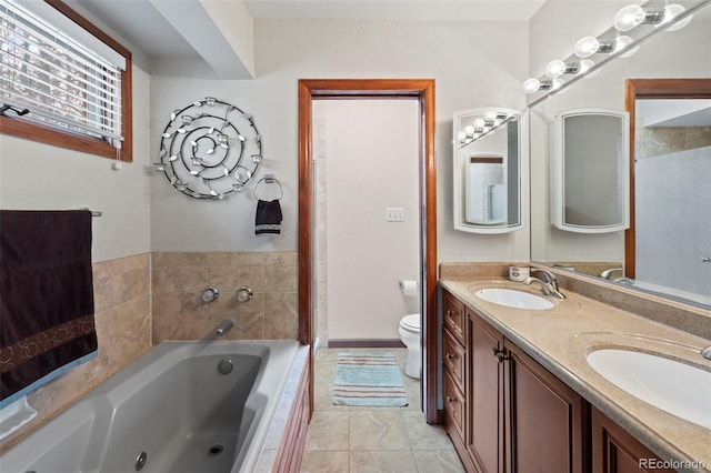 bathroom featuring tile patterned flooring, a relaxing tiled tub, vanity, and toilet