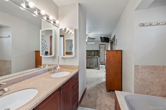 bathroom with ceiling fan, vanity, and tiled bath