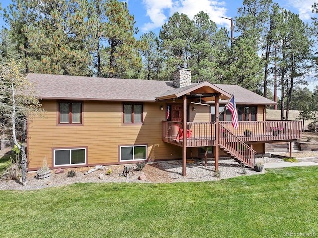 back of property featuring ceiling fan, a deck, and a lawn