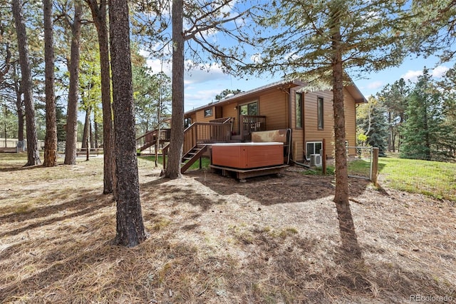 back of property featuring a wooden deck and cooling unit