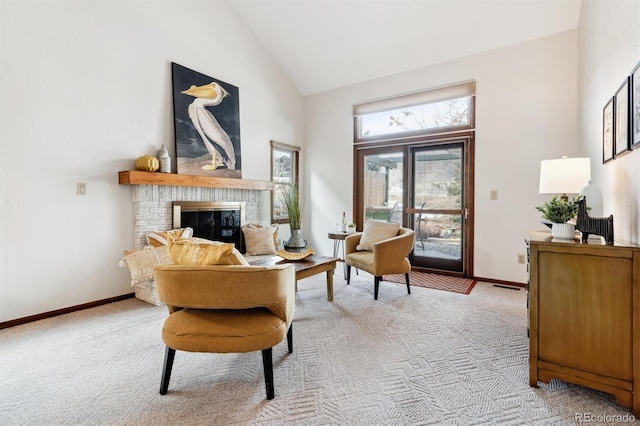 living area with light colored carpet, a fireplace, and high vaulted ceiling