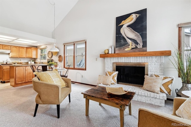 carpeted living room with a fireplace, sink, and high vaulted ceiling