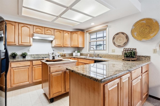 kitchen featuring light stone counters, stainless steel gas cooktop, a kitchen island, and sink