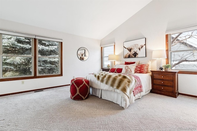 bedroom with multiple windows, light carpet, and vaulted ceiling