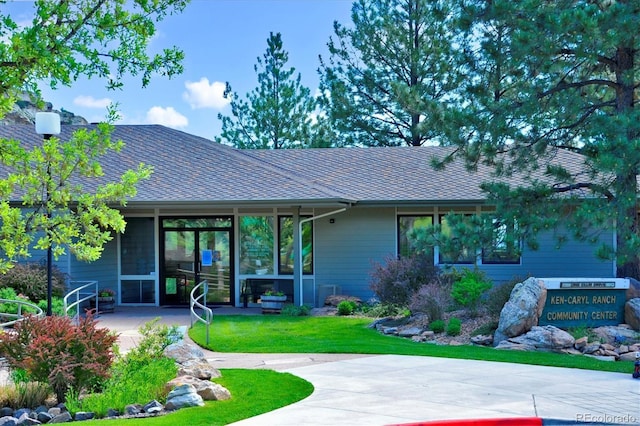 rear view of house featuring a lawn