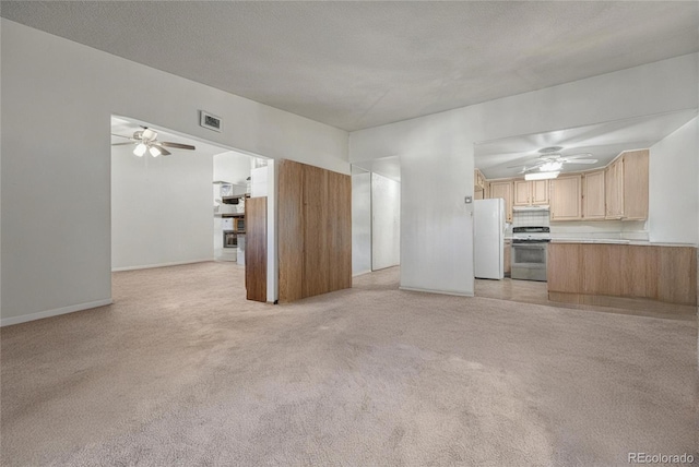 unfurnished living room with a textured ceiling, light colored carpet, and ceiling fan