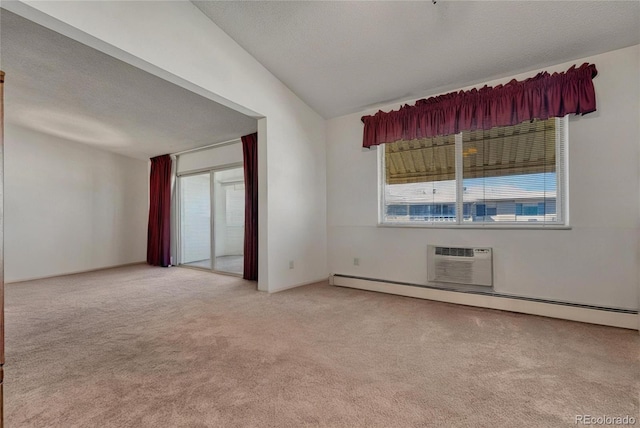 empty room with light carpet, a wall mounted air conditioner, a textured ceiling, and baseboard heating