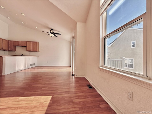 unfurnished living room with hardwood / wood-style flooring, ceiling fan, and lofted ceiling