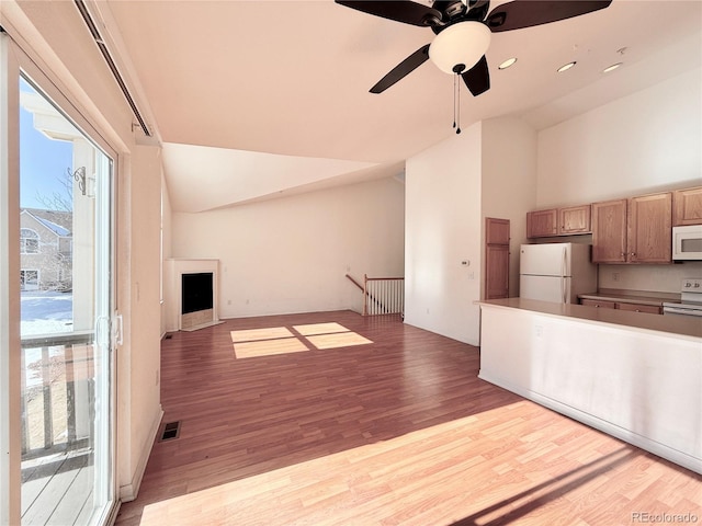 kitchen with ceiling fan, high vaulted ceiling, white appliances, and light hardwood / wood-style flooring