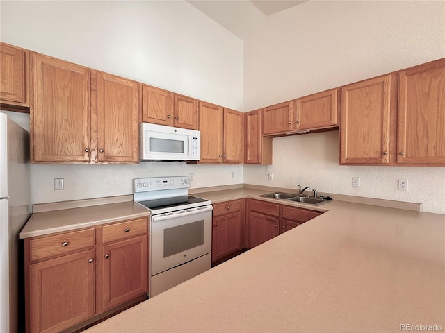 kitchen with white appliances, sink, and a towering ceiling