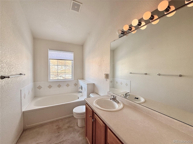 bathroom featuring vanity, toilet, a bathing tub, and a textured ceiling