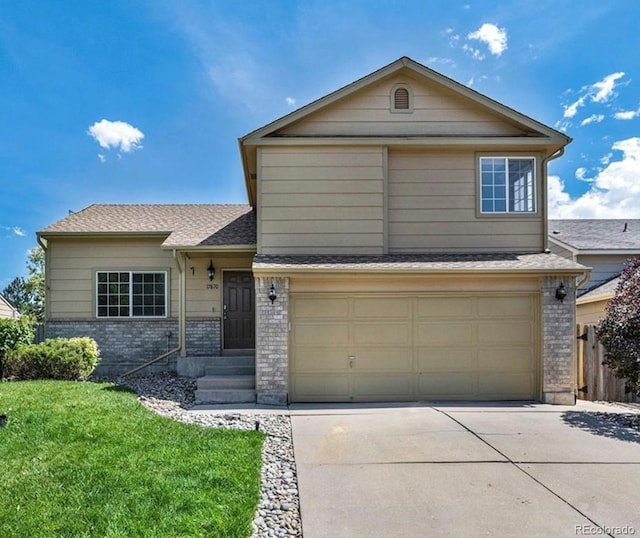 view of front of house featuring a garage and a front lawn