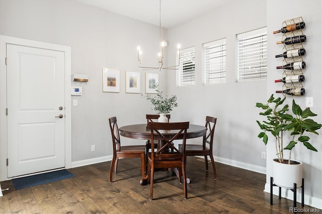 dining space with baseboards, hardwood / wood-style flooring, and an inviting chandelier
