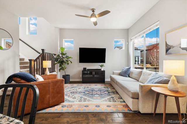 living room with baseboards, stairway, a ceiling fan, and wood-type flooring