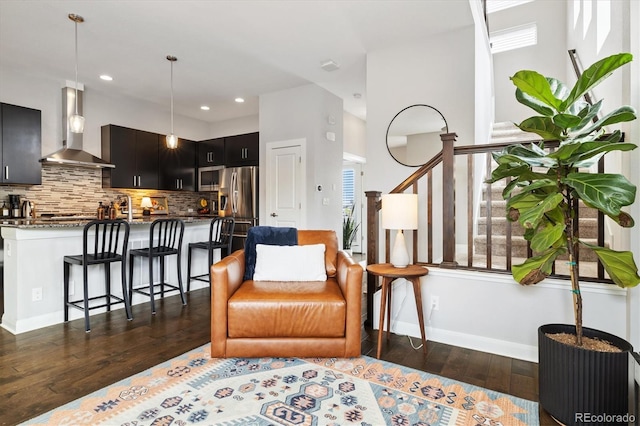 living area featuring dark wood finished floors, baseboards, stairs, and recessed lighting