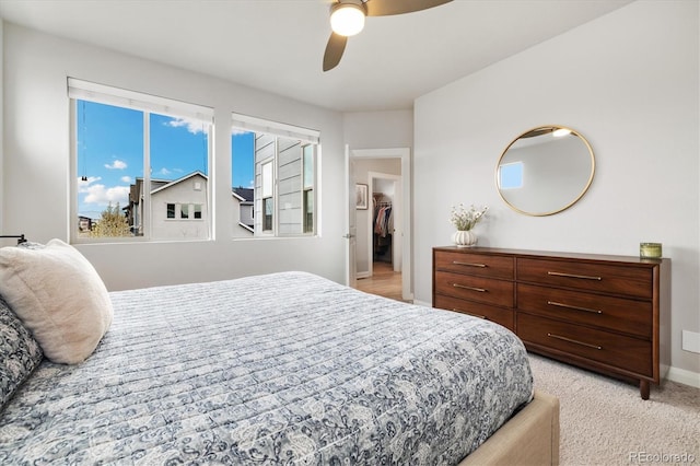 bedroom featuring baseboards, ceiling fan, and light colored carpet