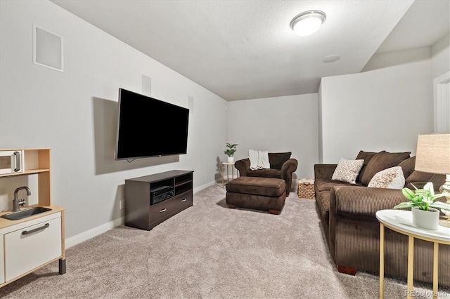 carpeted living area featuring baseboards and a sink