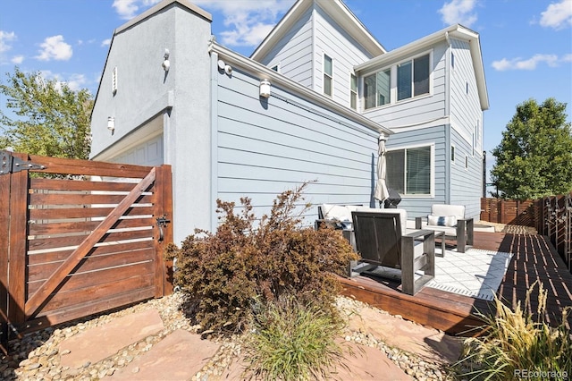 back of house featuring a gate, an attached garage, and fence