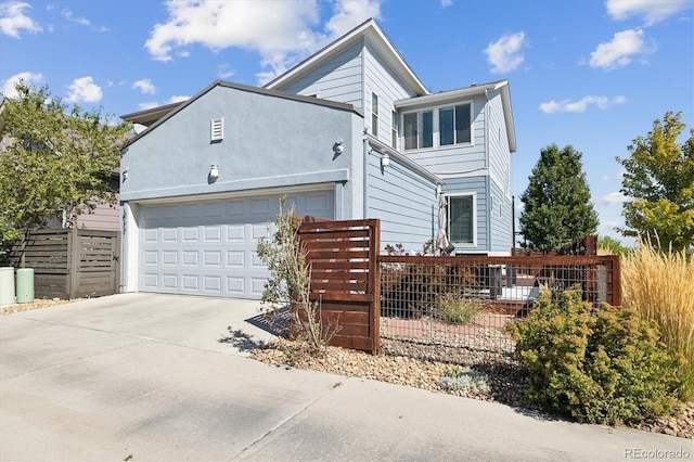 view of front of property with an attached garage, fence, and concrete driveway